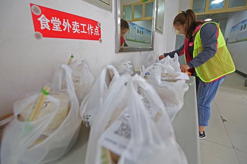 A woman is arranging bags from a food delivery