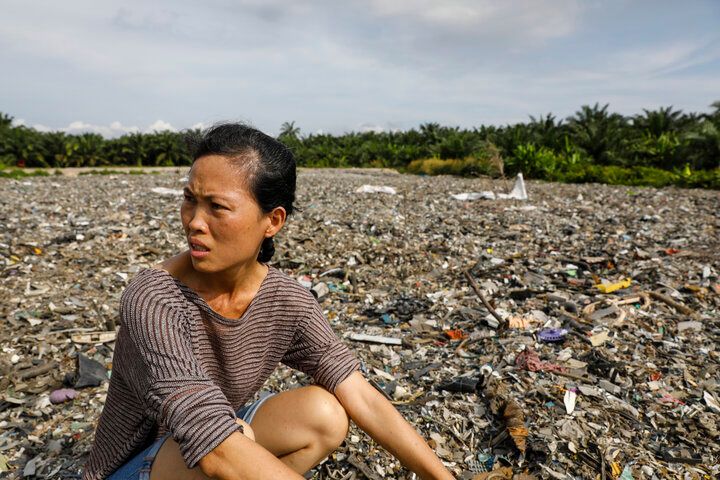 A Malaysian activist checks out an illegal plastic dumping site inside a palm oil estate in Kuala Langat. Shredded plastic was spread on the ground and left here. Often, the dumpers will return and burn the piles at night.