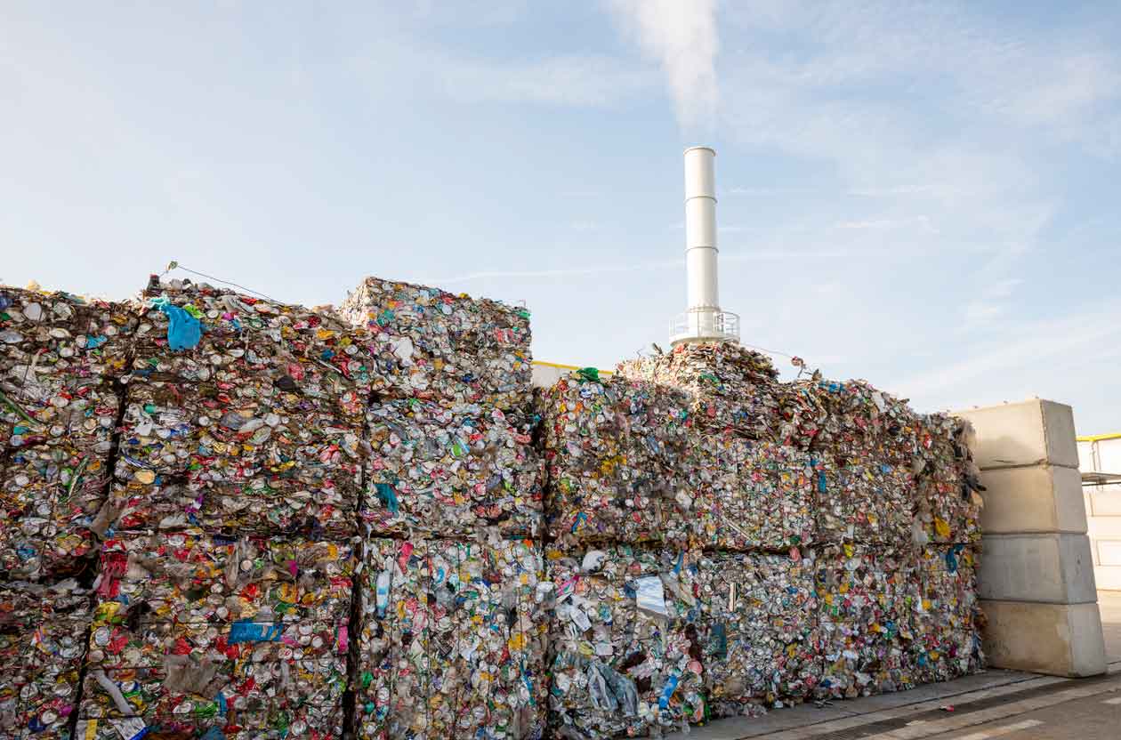 Waste-to-energy or energy-from-waste is the process of generating energy in the form of electricity or heat from the primary treatment of waste. Environmentally friendly. Cubes of pressed metal beer and soda cans.