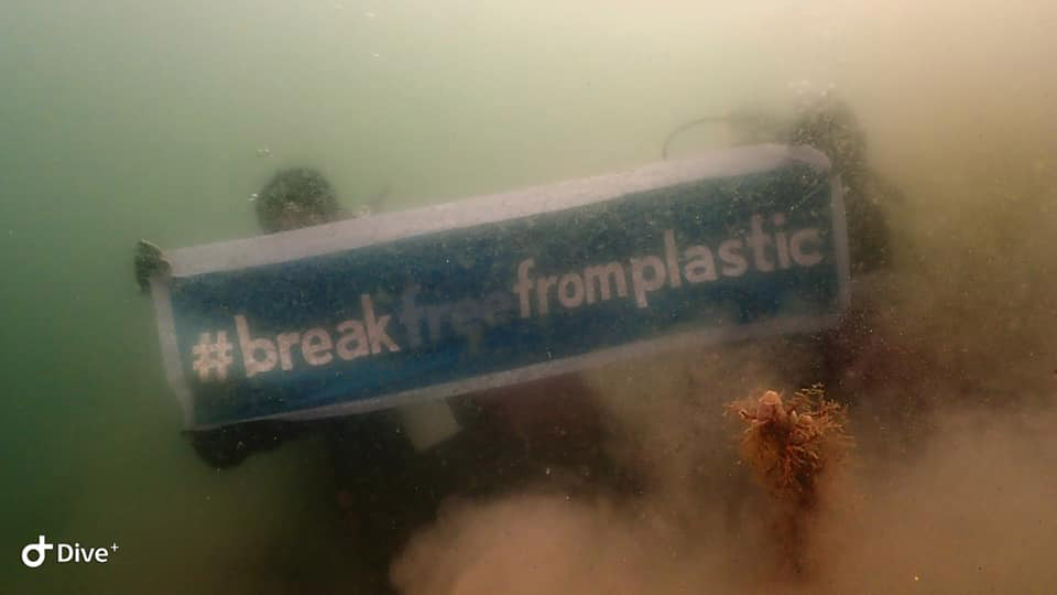 Two divers are holding a #breakfreefromplastic banner underneath the ocean during the #BrandAudit2019 in Davao del sur, Philippines.