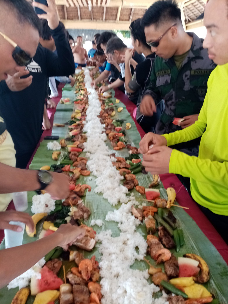 Participants including the coalition of 1101st Army Reserved Group, Sarangani Divers, Brgy. Almendras and SMSP Batch 80’s Advocacy for Environmental and Cultural Preservation, Inc are eating on top of leaves during the #BrandAudit2019 in Davao del sur, Philippines