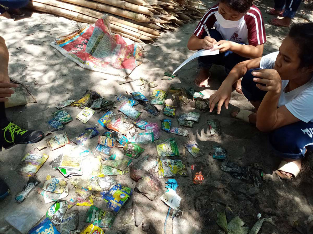 Participants are recording the name of the brands from the trash they have collected during the #BrandAudit2019 in Davao del sur, Philippines.