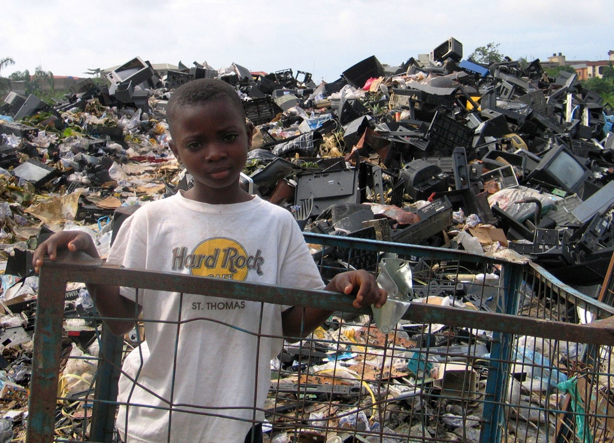 Boy standing on the market dumpsite, full of unrepairable electronic waste imported from Europe and North America for "reuse" in Lagos, Nigeria. Copyright BAN