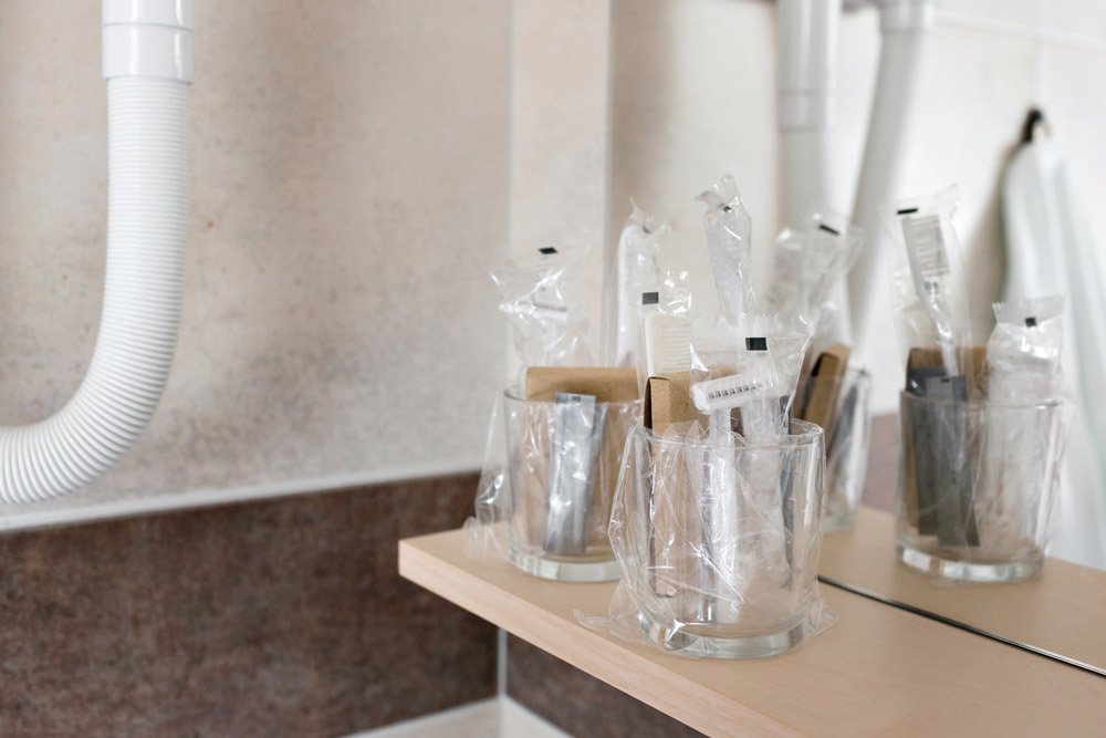 Close up view on the bottles with cosmetics and hygienic kit ain the hotel bathroom