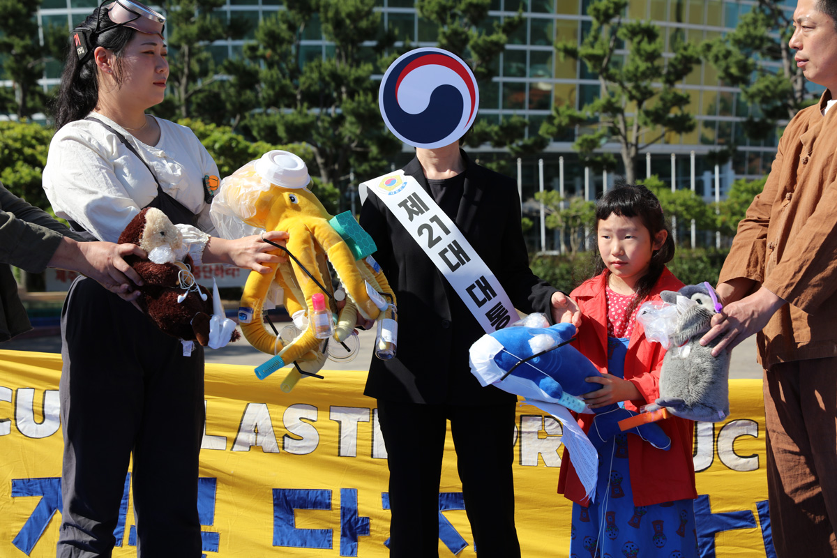A woman handing over a contaminated marine creature dolls